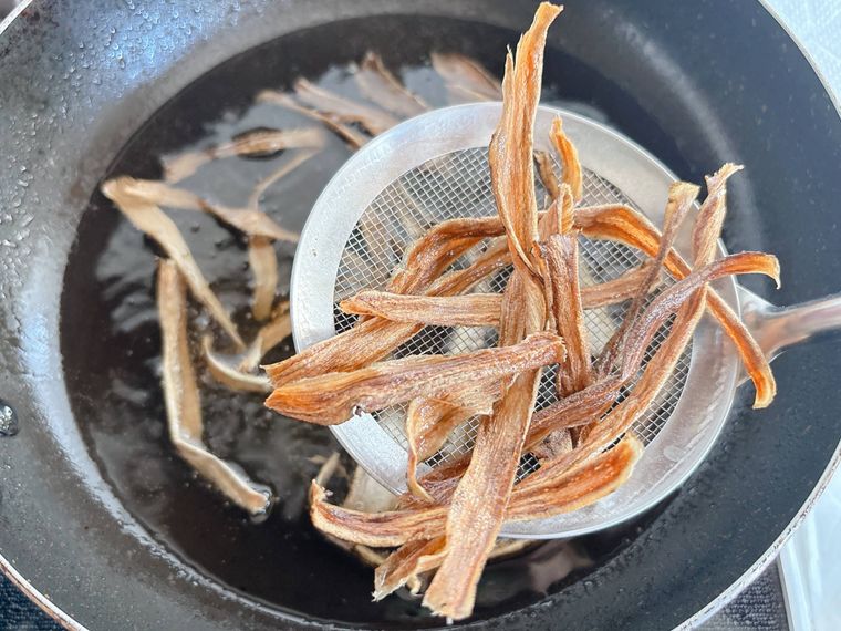 ピーラーでスライスしたごぼうを油から取り出す様子