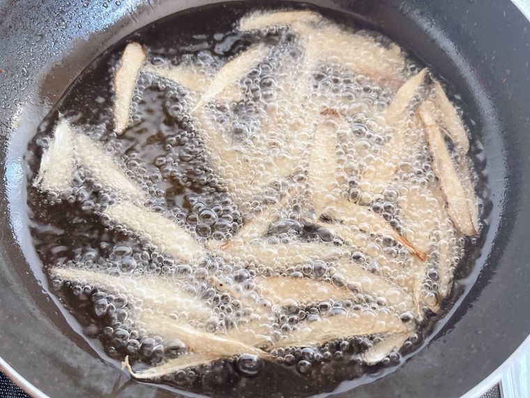 厚めにささがきにしたごぼうを揚げる様子
