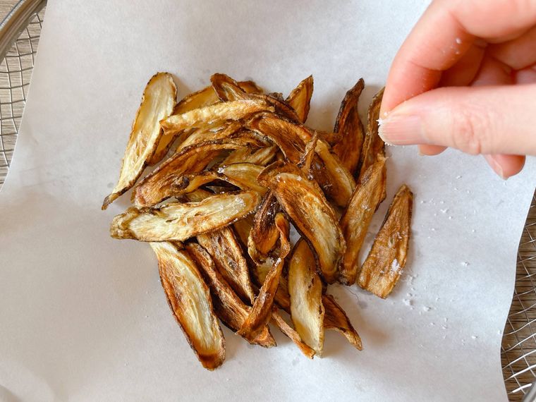素揚げしたごぼうに塩を振る様子