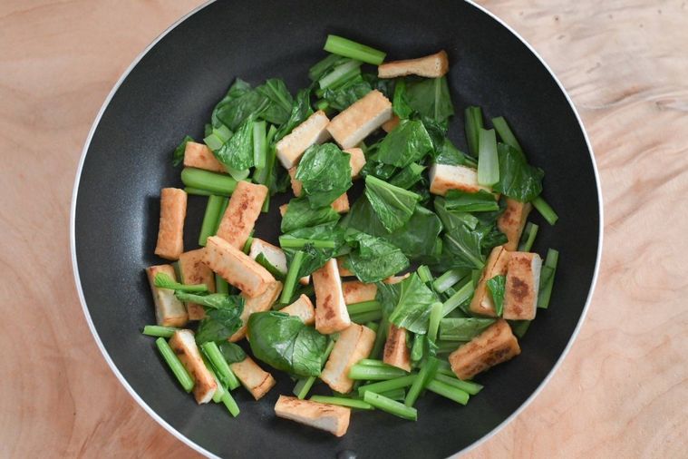 フライパンに入った味付け前の厚揚げと小松葉