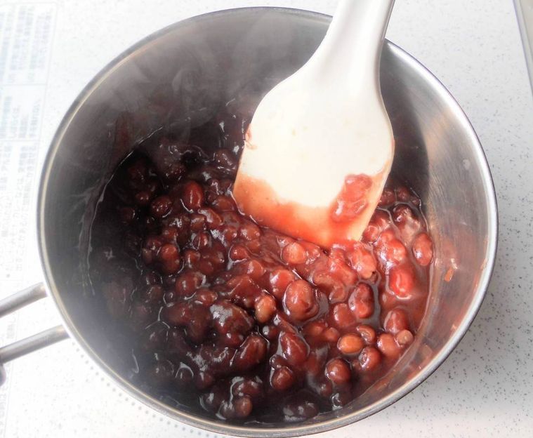 ゴムベラで混ぜながら、つぶあんを鍋で炊いている様子