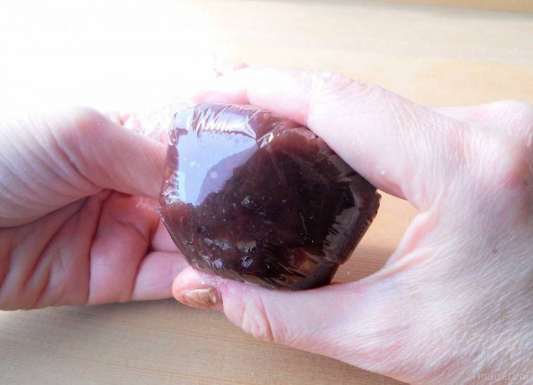 ラップごとおはぎを包んで、手で整えている様子