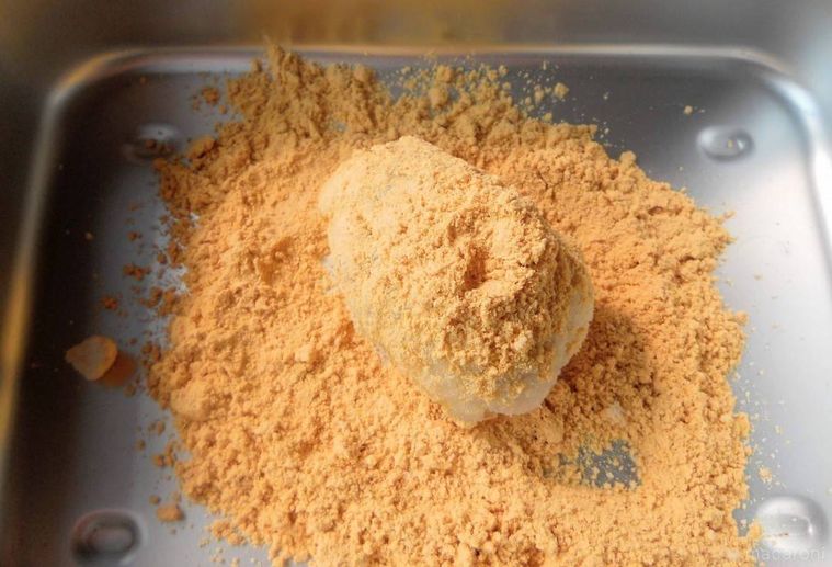 バットにきな粉を入れて、もちだねにまぶしている様子