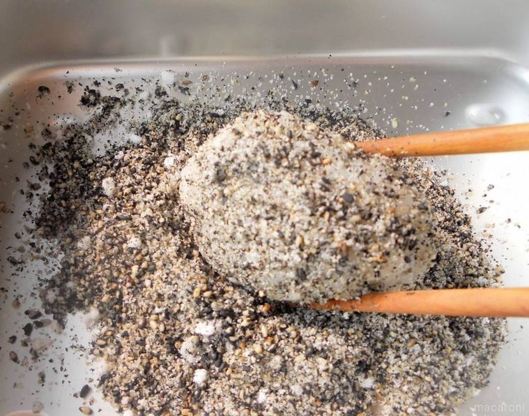 バットに黒すりごまともちだねを入れて、まぶしている様子