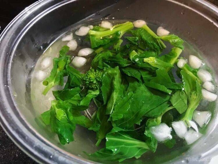 ボウルに冷水を張って菜の花を冷やしている様子