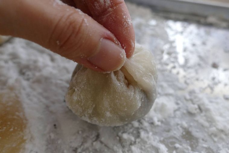 求肥を中心に寄せるようにこしあんを包む様子