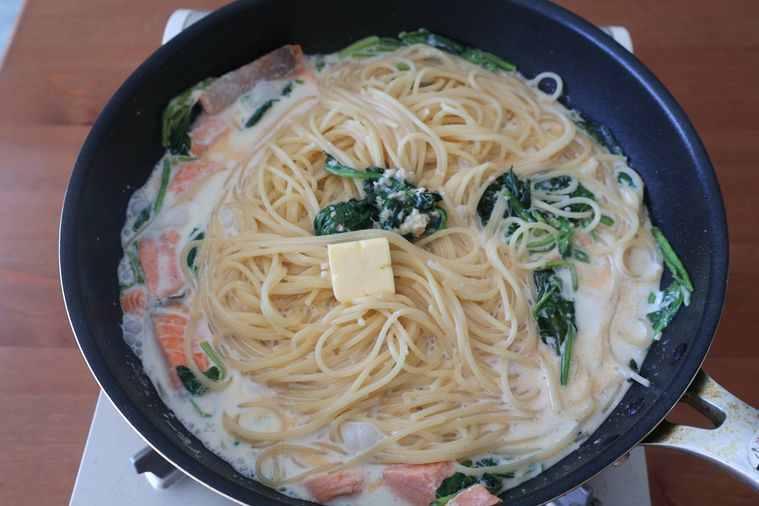 パスタのフライパンにバターを加えている