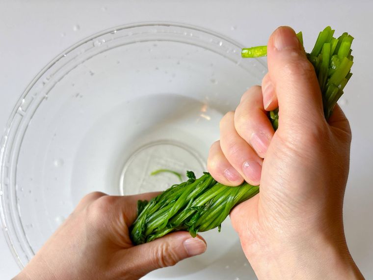 せりの水気を絞る様子