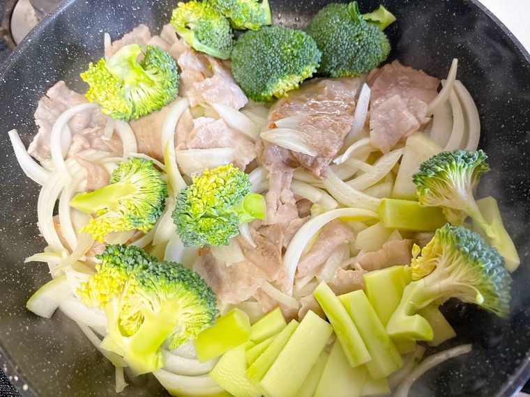 豚バラ肉と玉ねぎ、ブロッコリーを炒める様子