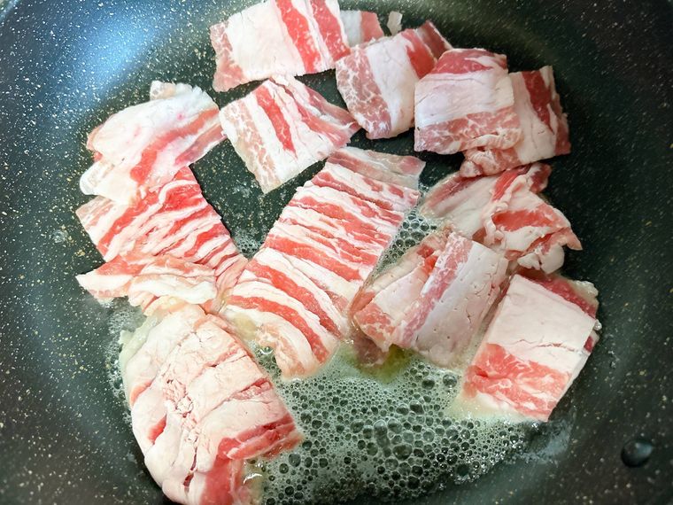 豚バラ肉をフライパンで炒める様子