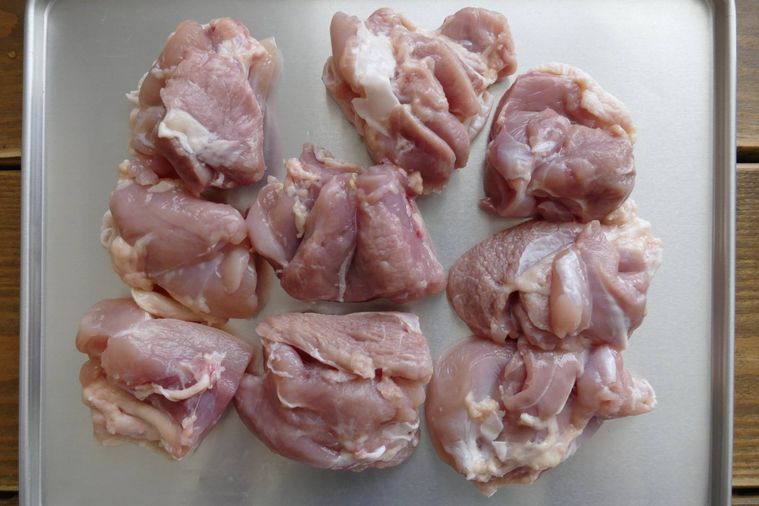 切った鶏もも肉が並ぶ金属トレー