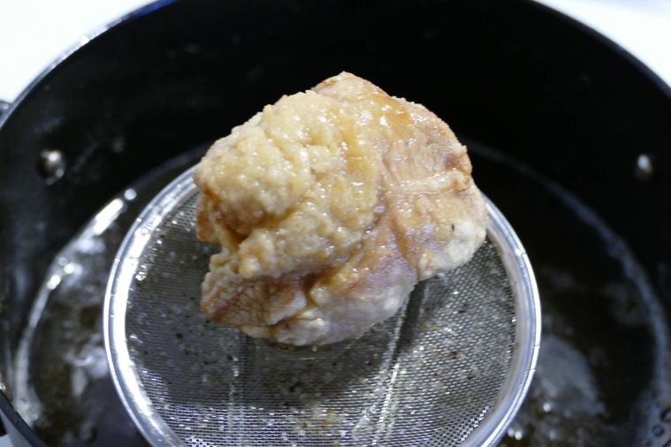 一度目の揚げを終えた唐揚げをすくい上げた様子