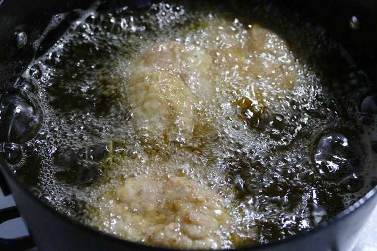 鶏もも肉を油鍋に入れた様子