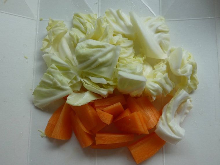 まな板に乗ったざく切りキャベツと短冊切りにんじん