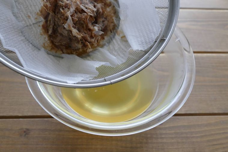だし汁をザルとキッチンペーパーでこす様子