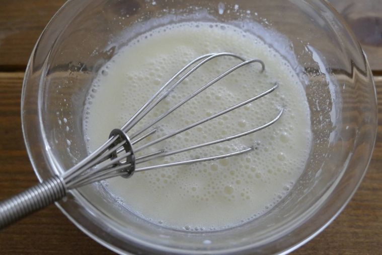 牛乳とサラダ油を泡だて器で混ぜる様子