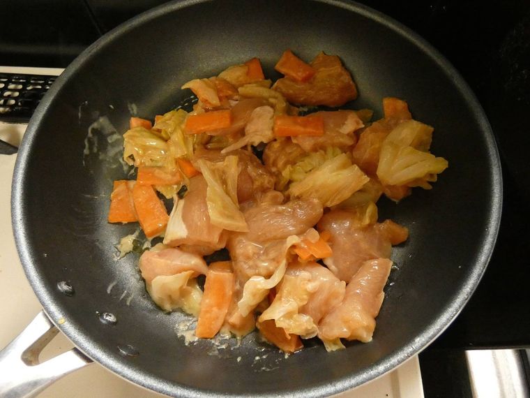 フライパンで炒めている鶏むね肉と野菜