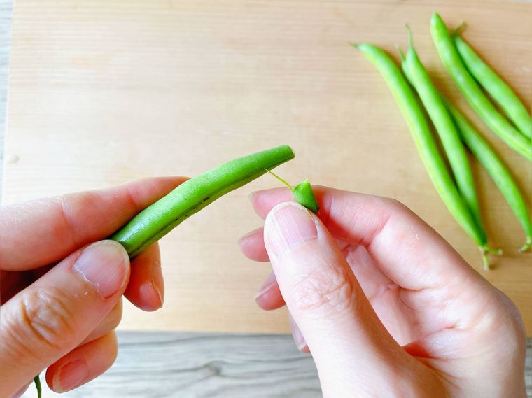 いんげんの筋取りをする様子