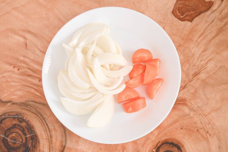 皿にのった皿下処理をした玉ねぎとにんじん