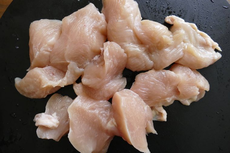 そぎ切りにした鶏むね肉がのっているまな板