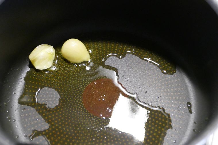 鍋でにんにくを炒める様子