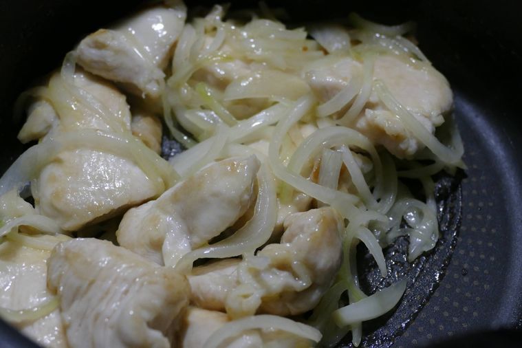 薄切り玉ねぎを加えて炒める様子