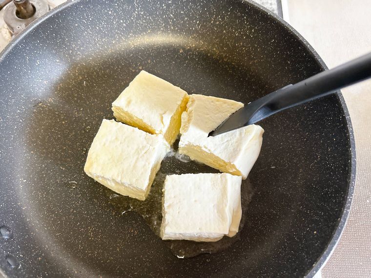 ゴムベラで木綿豆腐を割る様子