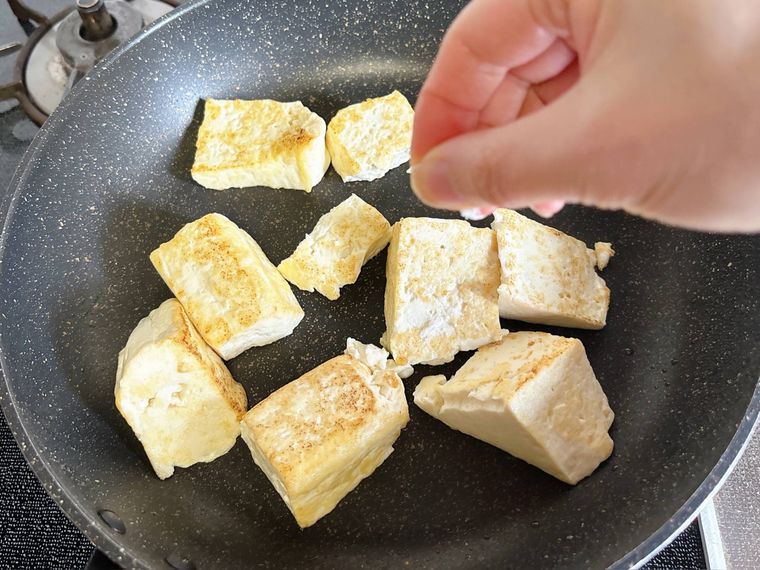 木綿豆腐に塩をふる様子