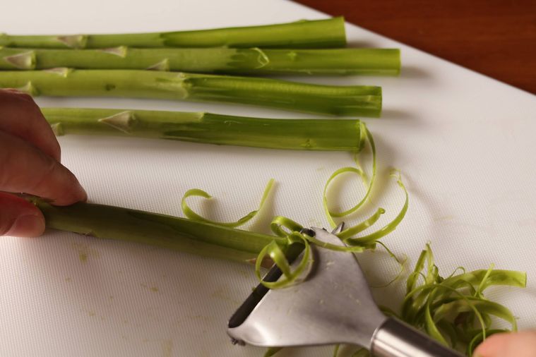 アスパラの皮をむいている