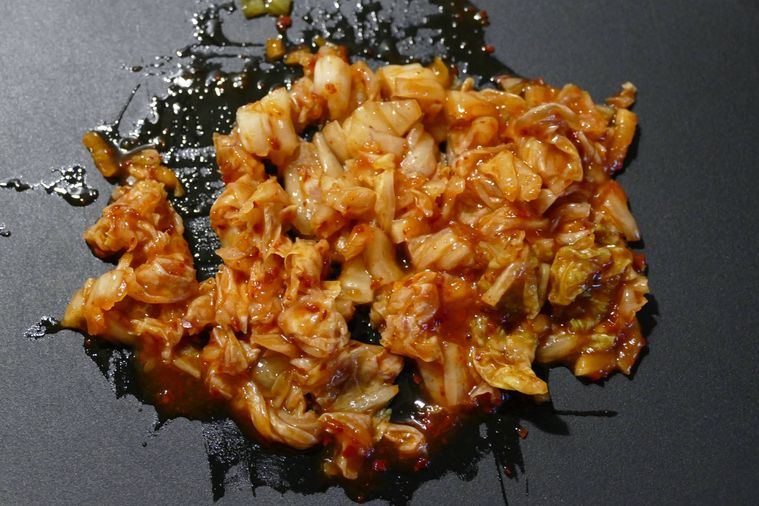 みじん切りされた白菜キムチがのっているまな板