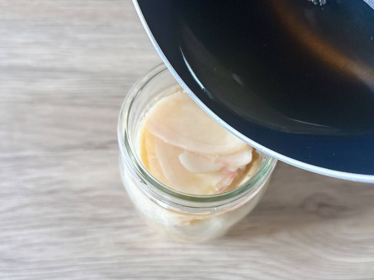 保存瓶に入った新生姜に甘酢を入れる様子