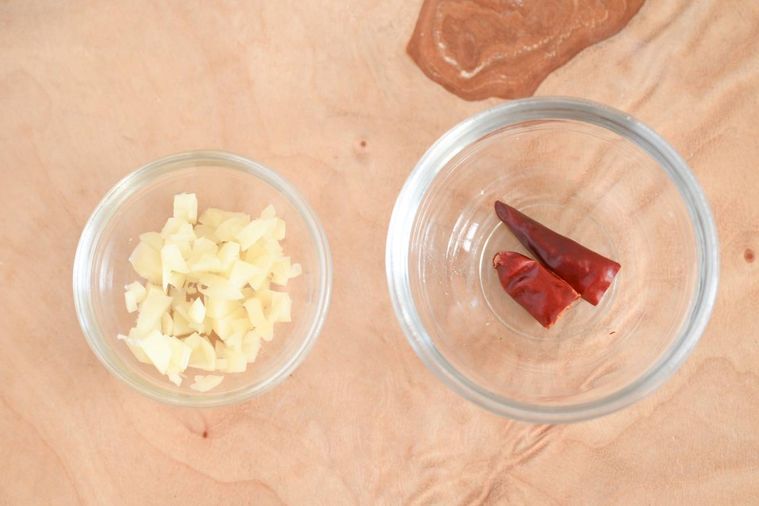 ガラス容器に入ったカット済みのにんにくと唐辛子