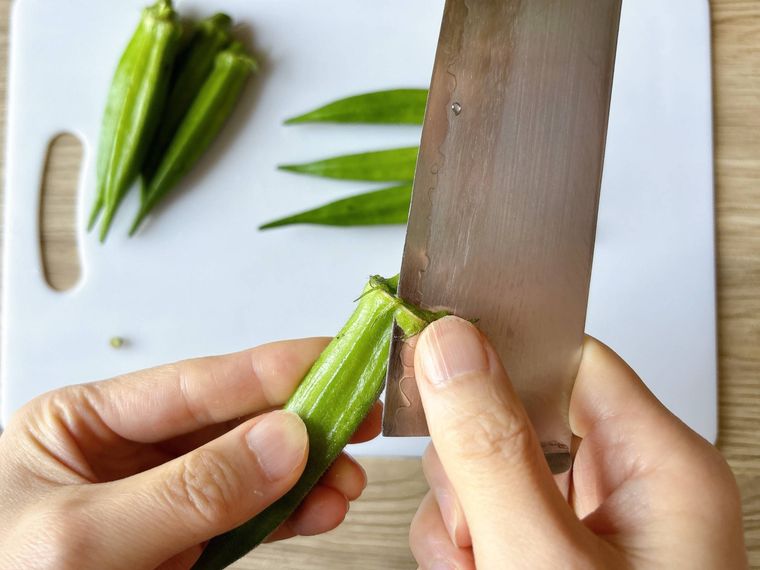 オクラのガクをそぐようにしてむく様子