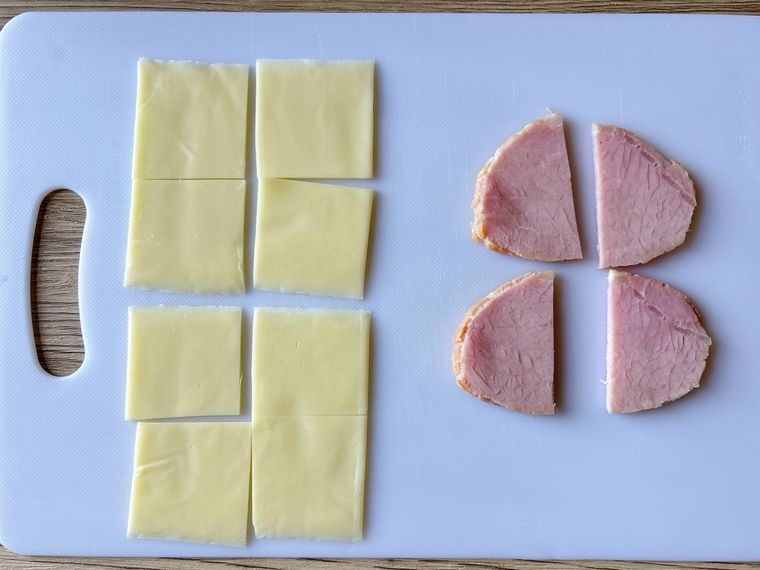 まな板におかれた4等分にカットした半分にカットしたハム