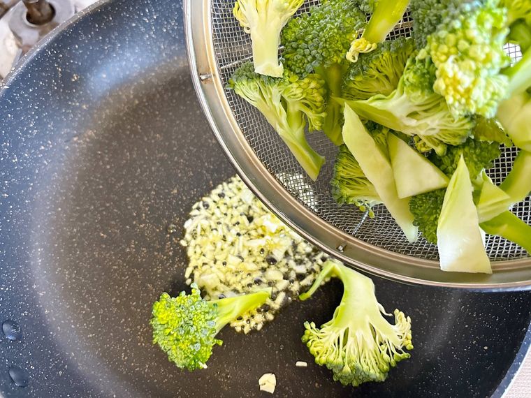 フライパンにブロッコリーを加える様子