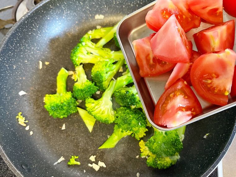 ブロッコリーにトマトを加える様子