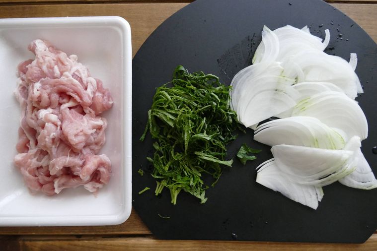 下味をもみ込んだ豚こま肉、刻んだ大葉、薄切りの玉ねぎが並ぶ木製テーブル