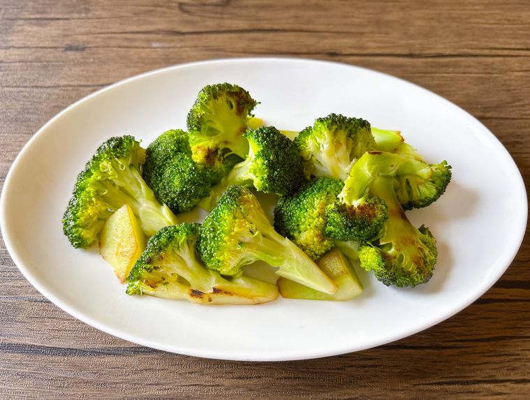 楕円の白色の皿に盛られた炒めたブロッコリー