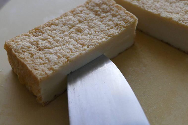 厚揚げの断面に包丁で切り込みを入れる様子