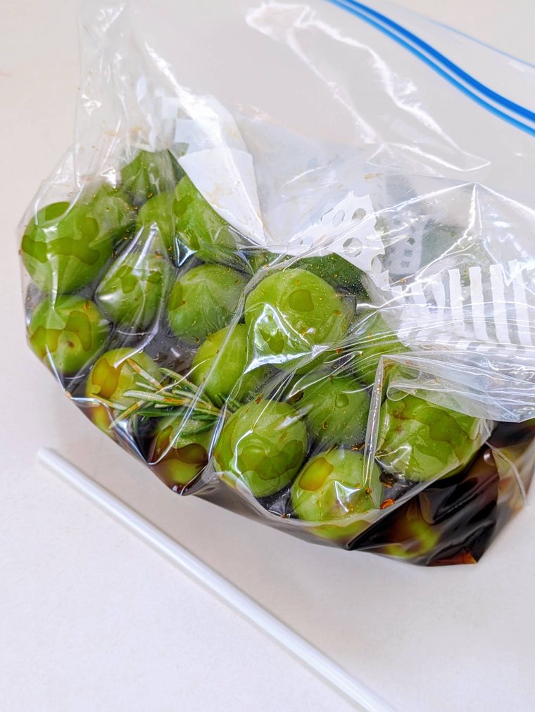 ジッパー付きの保存袋に入れた梅としょうゆとハーブ類、空気を抜く為のストロー