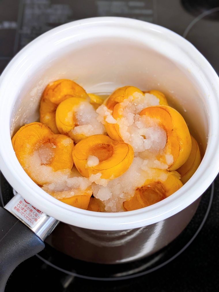 加熱前の鍋に入ったあんずと砂糖、あんずから出た汁。