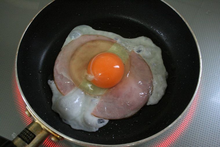 フライパンでハムエッグを作っている様子