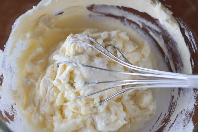 泡立て器でクリームチーズを練っている