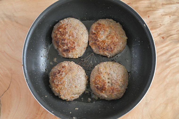 フライパンに入った焼き色のついたハンバーグ