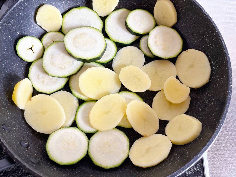 フライパンにズッキーニとじゃがいもを入れた様子