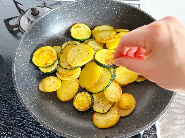 ズッキーニとじゃがいもに塩こしょうする様子