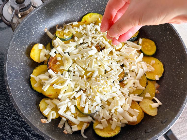 ズッキーニとじゃがいもにとろけるチーズをのせる様子