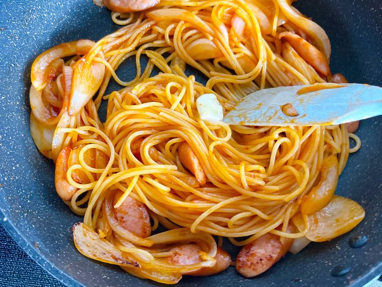 ナポリタンにバターを加えて混ぜるようす
