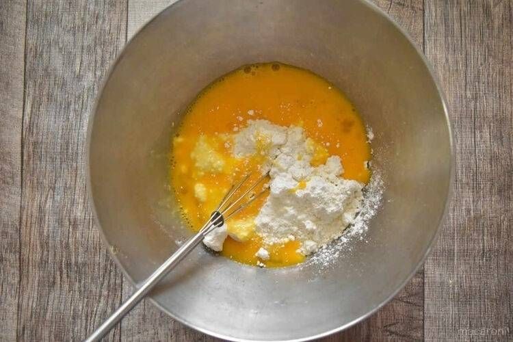 卵が入ったボウルに、小麦粉を入れ混ぜている様子