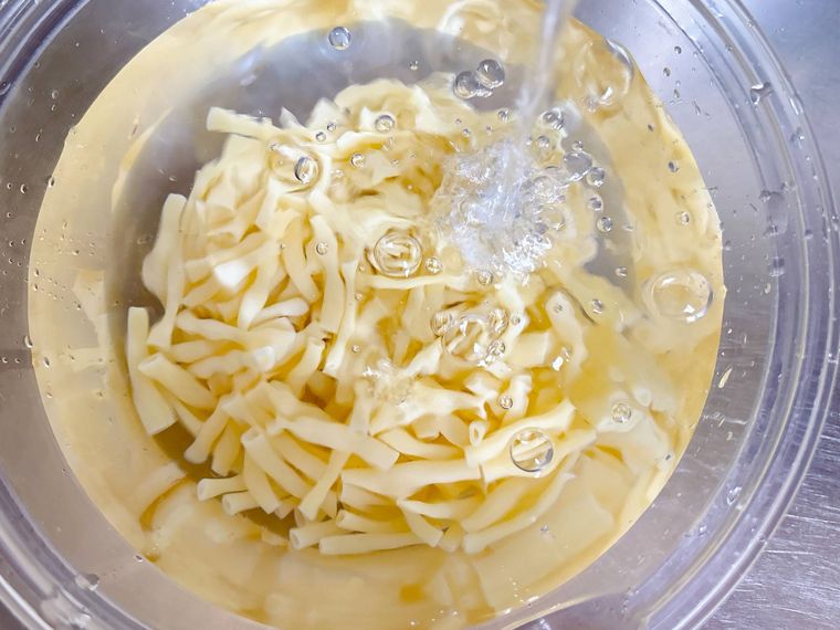 ゆで上がったマカロニを冷水にさらす様子